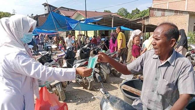 
 Pihak UPTD Puskesmas Buket Gadeng sedang membagikan masker kepada warga, Selasa 24 Juni 2025 di Pasar Buket Gadeng