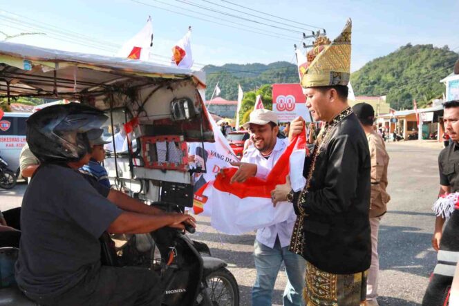
 Bupati Aceh Selatan H.Mirwan didampingi Sekretaris Partai Gerindra Aceh Selatan Alja Yusnadi membagikan bendera merah putih kepada pengguna jalan di seputaran kota Tapaktuan, Sabtu 16 Agustus 2025.