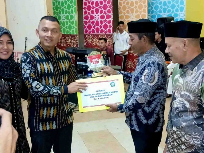 
 Camat Kluet Selatan Muriadi SH sedang menerima hadiah juara pertama Nuansa Merah Putih HUT RI ke 80 oleh Dandim 0107/Aceh Selatan Letkol Inf Faiq Fahmisaat, Minggu 17 Agustus 2025 di Gedung Agam Tapaktuan.