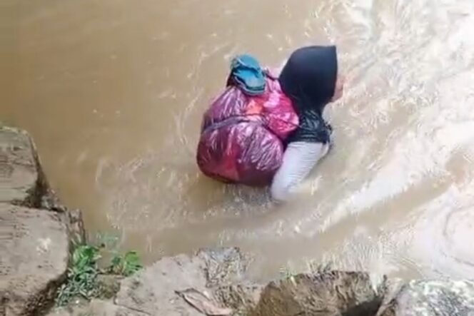 
 Foto : Bidan Dona Lubis menyeberangi sungai demi mengobati pasien, Jum'at (1/8) 