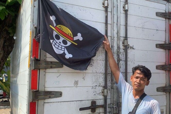 
 Seorang sopir truk di Kranji, Bekasi Barat, Kota Bekasi, Dadang (28), memasang bendera bajak laut dari manga One Piece di bagian belakang boks kendaraannya.(ACHMAD NASRUDIN YAHYA/KOMPAS.com)  